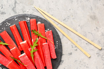 Slate board with tasty crab sticks on grunge background, closeup © Pixel-Shot