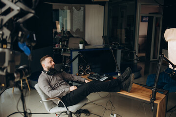 Man radio host or representer or journalist reads news from paper list in hand to studio microphone...