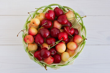Cherries in a basket on the table. Ripe sweet delicious cherries in a wicker basket. Summer berries close-up. Vegetarian food, healthy fruits from the garden, rich in vitamins. Harvesting by farmers