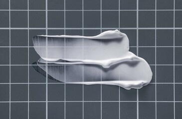 White cream smudge swatch textured on gray colored line board background