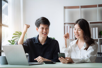 Asian couple looking laptop with happy together in the home. Success of lovers in front of a notebook. Happy couple on social online with a laptop.