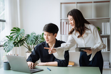 Obraz premium cute cheerful young couple using laptop and analyzing their finances with documents.