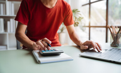 Hand businessman doing finances and calculate on desk about cost at home office..