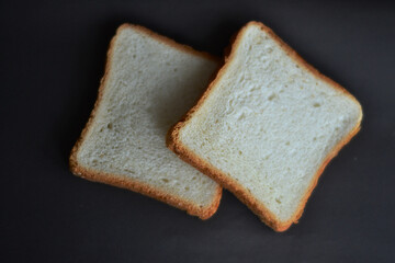 Two pieces of bread on a black background