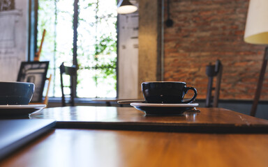 Two cups of coffee and a laptop computer on wooden table