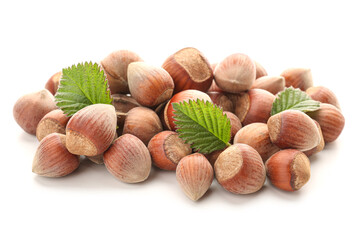 Shelled hazelnuts with leaves on white background