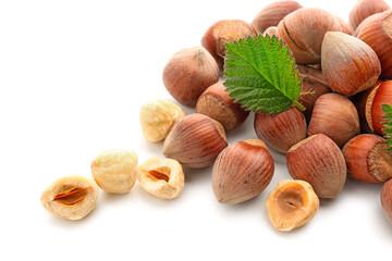 Shelled hazelnuts with leaf on white background