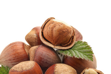 Shelled hazelnuts with leaf on white background