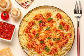 Plate of tasty Italian pasta with Parmesan cheese and ingredients on white background