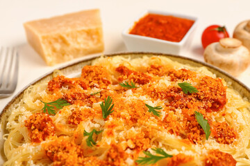 Plate of tasty Italian pasta with Parmesan cheese on white background, closeup