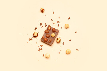 Sweet tasty chocolate with nuts on  beige background