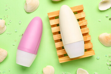 Obraz premium Deodorants with shells, stones and sea salt on light green background