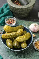 Bowl with tasty fermented cucumbers on dark grunge background
