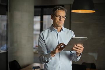 Obraz na płótnie Canvas Portrait of businessman in office. Man using digital tablet. Businessman having video call..