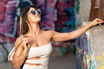 Attractive fit young woman posing in front of graffiti wall.