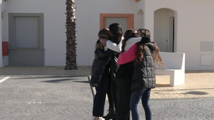 Young women meet on the street and hug each other