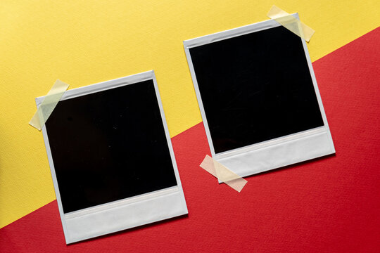 Download Blank photo frames template on red and yellow background. Blank square photo frames with tape on wall copy space