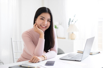 Portrait of the beautiful asian businesswoman , she is sitting at the table at workstation