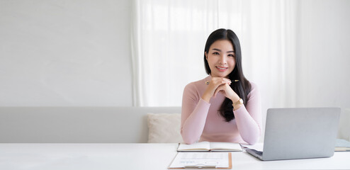 Portrait of the beautiful asian businesswoman , she is sitting at the table at workstation