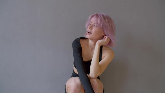 Crying depressed charming pink haired woman dancer in emotional stress sitting in studio, expressing hopelessness, despair and sadness after failure audition to dance group.
