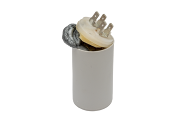 A faulty starting capacitor for electric motors was torn on a white background, the internal composition tore off the lid and went outside, repair of electrical appliances, replacement of elements.