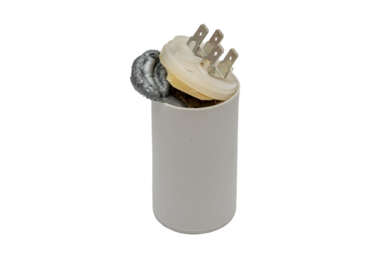 A faulty starting capacitor for electric motors was torn on a white background, the internal composition tore off the lid and went outside, repair of electrical appliances, replacement of elements.
