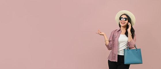 Portrait of cheerful young woman wearing summer clothes and sunglasses isolated on pink background with copy space