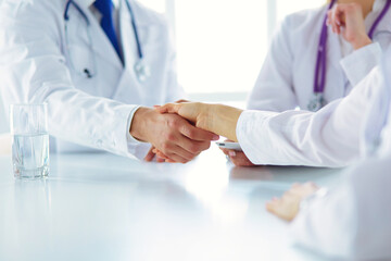 Doctor shaking hands with a male patient in the office.