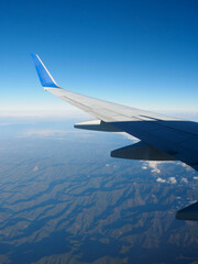 Fototapeta na wymiar 飛行機の窓からの景色・雲と青空