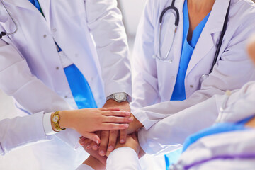 Doctors and nurses in a medical team stacking hands.