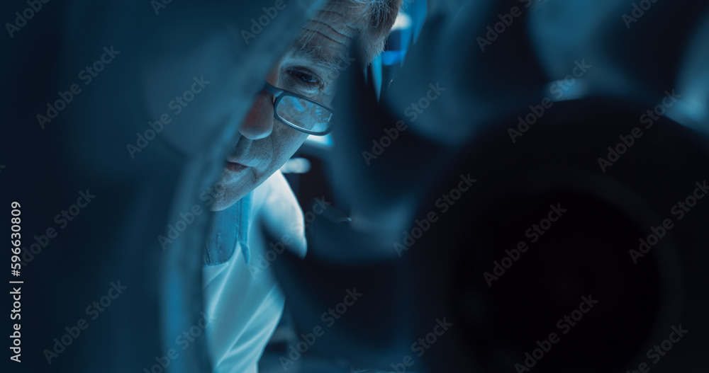 Aufkleber Close Up Portrait of a Middle Age Engineer in Glasses Examining a Rotating Fan on a High Tech Jet Engine. Research and Development Process of an Advanced Jet Engine in a Technology Startup