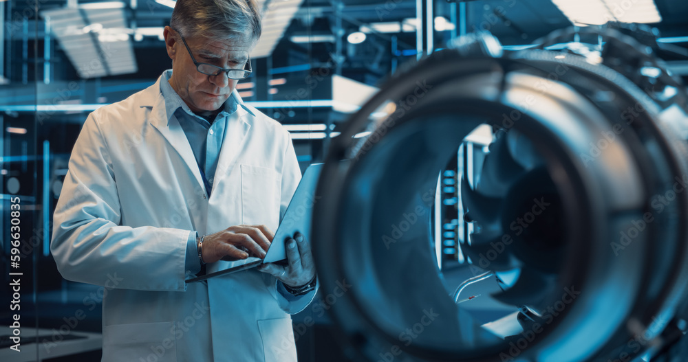 Aufkleber Middle Aged Caucasian Engineer Using Laptop Computer, Analyze and Research How a Futuristic Turbine Engine Works. Senior Manager Developing an Advanced Technology