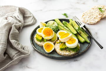 Healthy breakfasts, rice cakes with avocado and boiled eggs with dill and cucumber with spices, healthy wholesome food