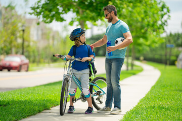 Happy fathers day. Happy family, men generations. Concept of friendly family and summer lifestyle. Father and son riding bike in american neighborhood. Parents and children friends. Child first bike.