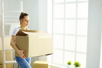 A beautiful single young woman unpacking boxes and moving into a new home.