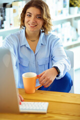 Happy woman working using multiple devices on a desk at home.