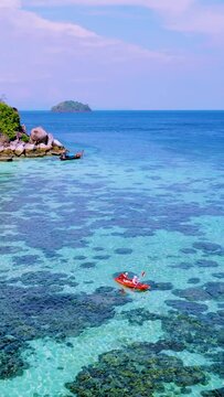 couple in kayak in the blue ocean of Koh Lipe Thailand padling to a small island in front of ko lipe island