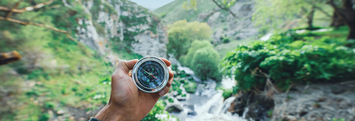 man holding compass in nature © Daniel