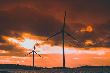 Obraz premium silhouettes of windmills in a snowy field at sunset