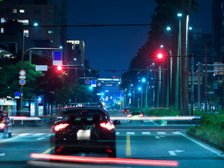 夜の都会の大きな道路を走る車