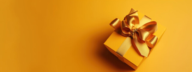 Gift box with gold satin ribbon and bow on yellow background. Holiday gift with copy space - Generative AI