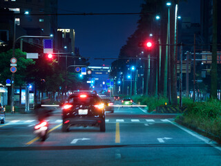 夜の都会の大きな道路を走る車