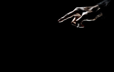 Human hand reaching out,one Finger Pointing Important Infortmations. Hand Presenting Crutial Announcement on black background with copy space