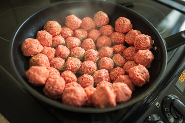 Raw beef and pork meat balls frying in wok