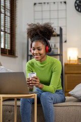 An American teenage woman is in the living room, she is spending her weekends at home playing social media and watching movies. The concept of living on vacation.