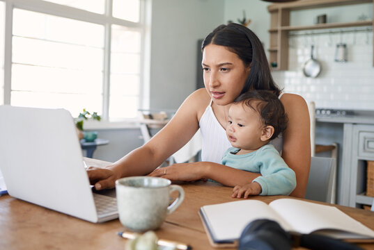 Watch mom do her thing. Shot of a mom working on her laptop with her baby on her lap.