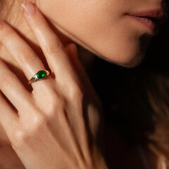 Beautiful woman closeup profile portrait with natural manicure wearing a ring with green gem - 596640606