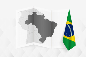 A grayscale map of Brazil with a hanging Brazilian flag on one side. Vector map for many types of news.