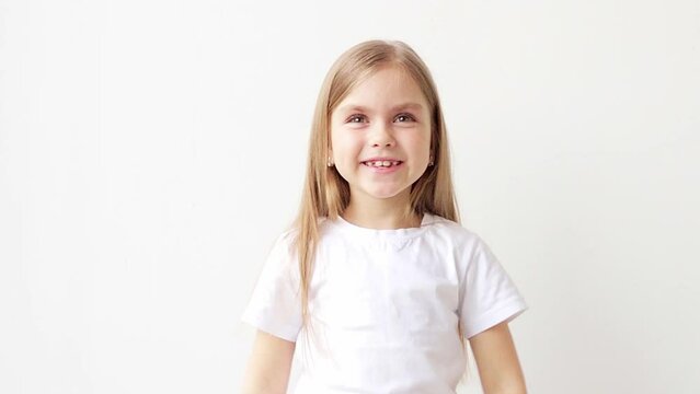 Beautiful young girl on a white isolated background shows emotions