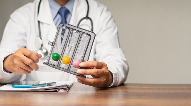 Doctor holding an incentive spirometer to help perform deep breathing exercises while sitting in the hospital
